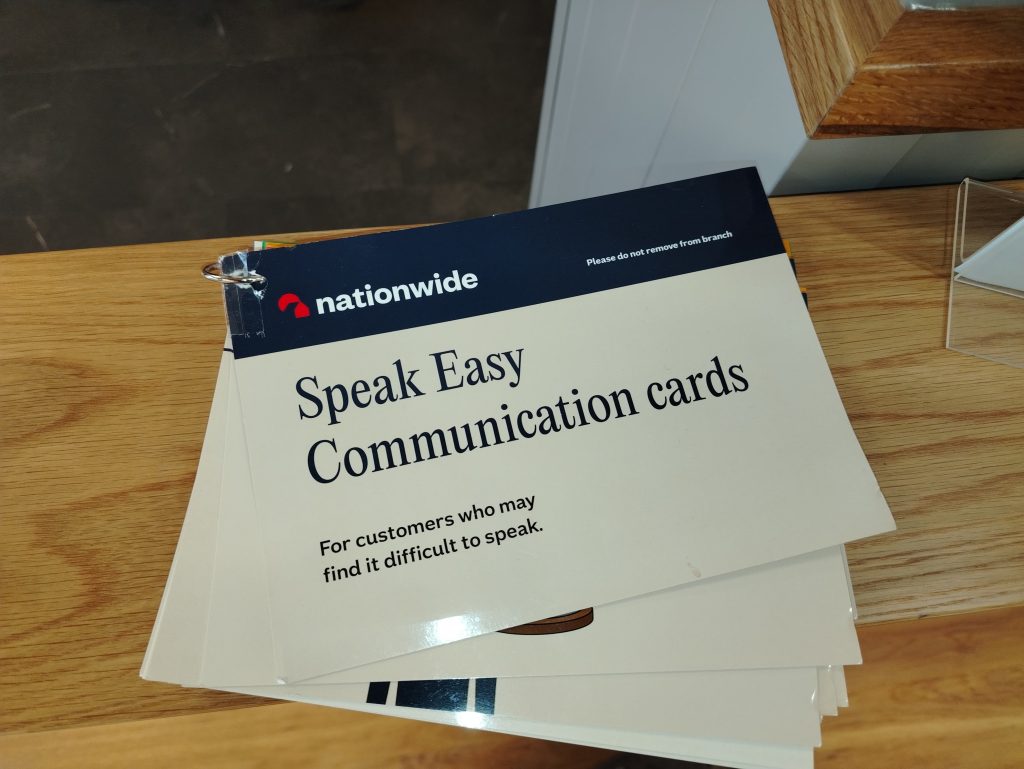 A picture of communication cards at Nationwide (bank/building society).  The front card reads "speak easy communication cards for customers who may find it difficult to speak"