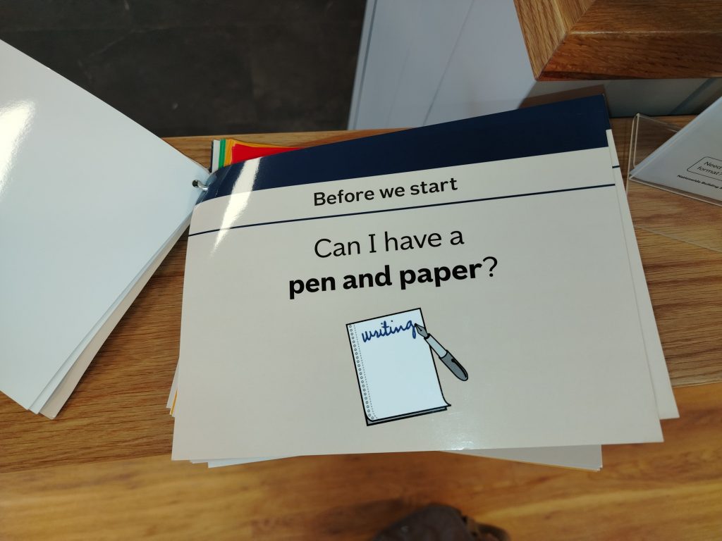 Picture of a communication card at Nationwide bank/building society. The card reads "before we start" at the top, and the main text reads "can I have a pen and paper?"